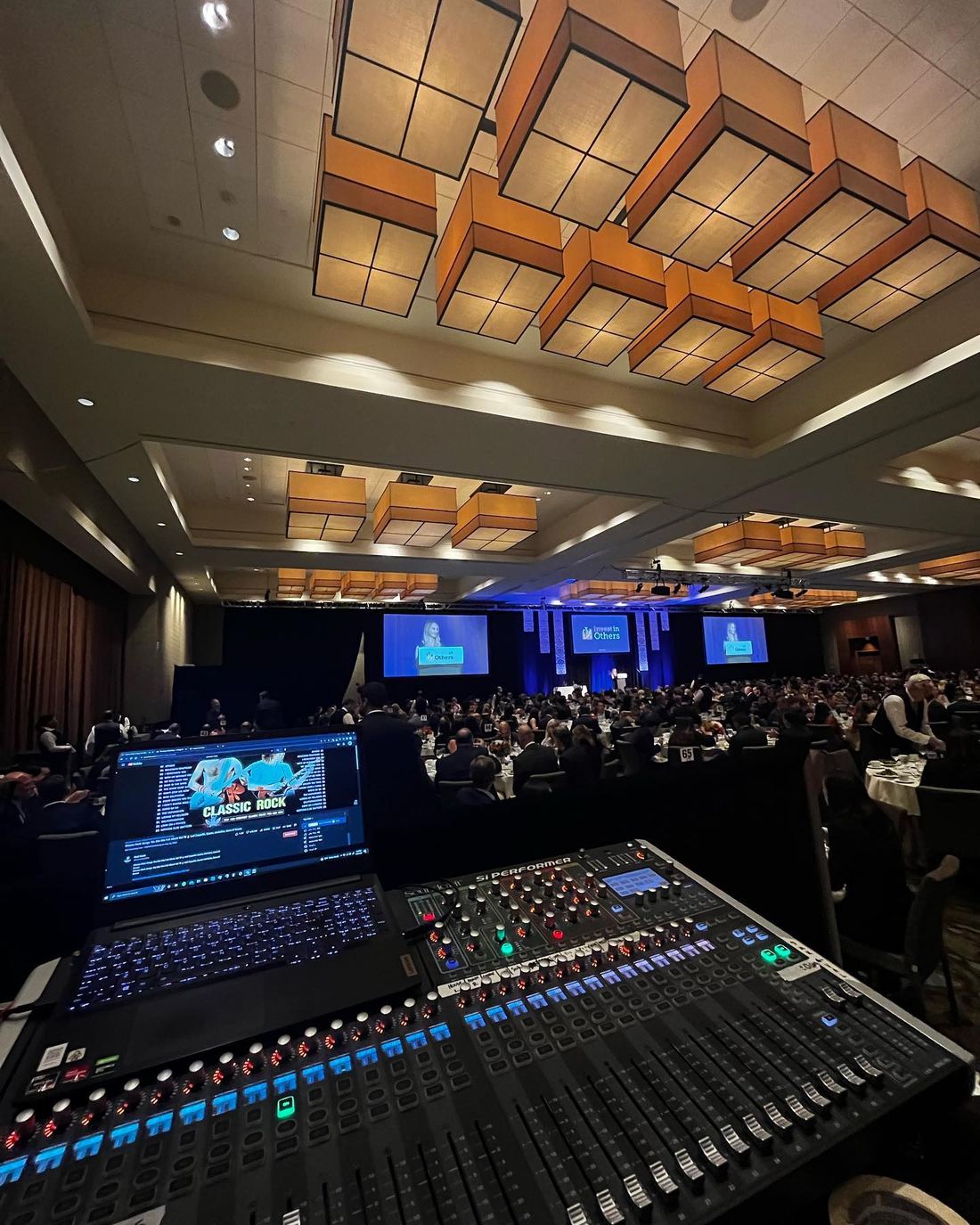 Digital mixer at the back of a warm wood-ceiling venue
